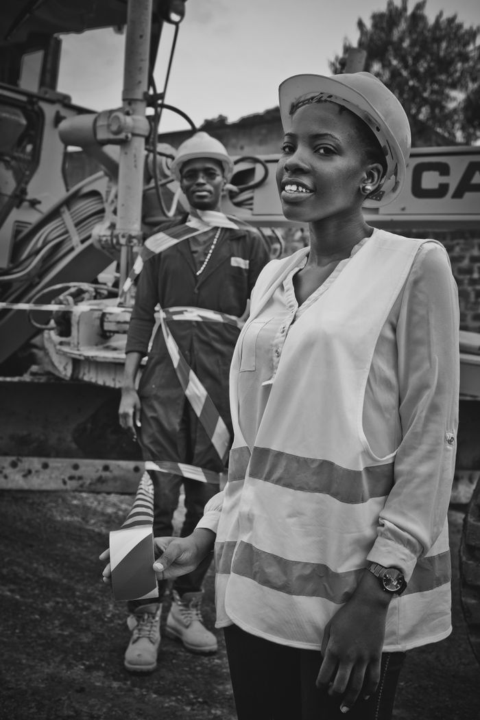 Black and white African American colleagues with warning tape having fun at construction site